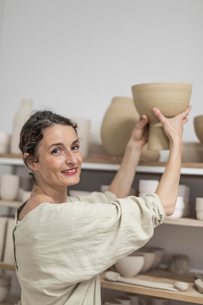 Portrait of female potter holding pottery