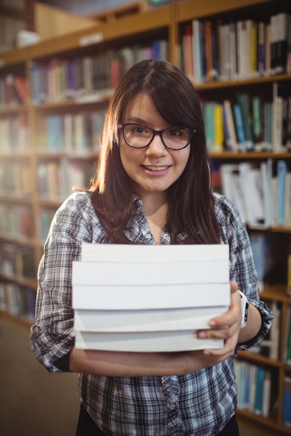 図書館で本の山を保持している女子学生の肖像画