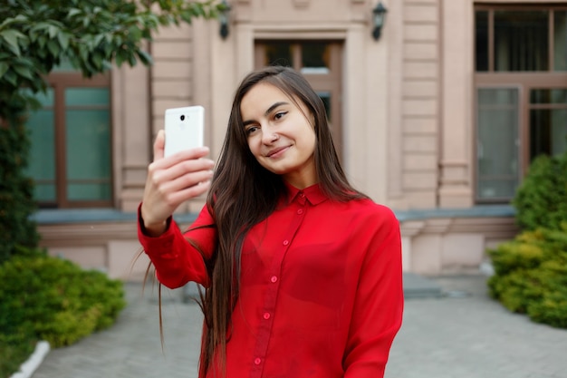 Portrait female in stylish outfit making selfie