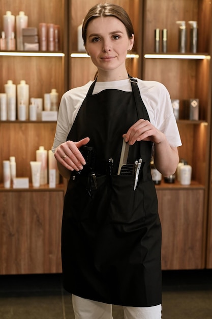 A portrait of female stylist or business owner in small beauty salon