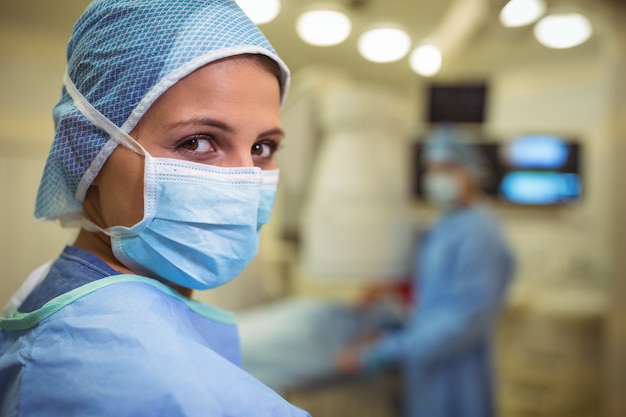 手術室でサージカルマスクを身に着けている女性外科医の肖像画