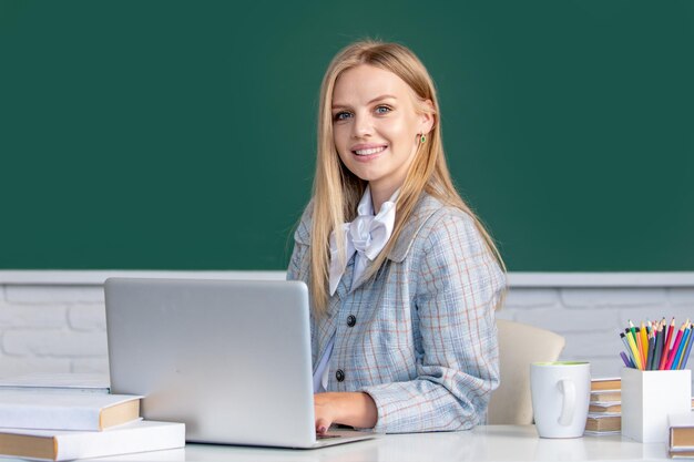 Portrait of female university student study lesson at school or\
university on blackboard background