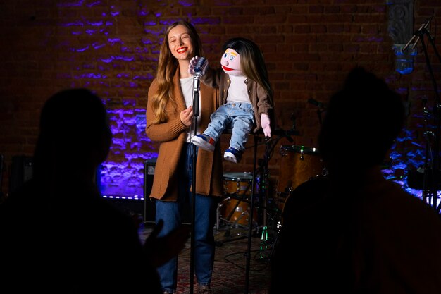 Photo portrait of female ventriloquist during show with puppet