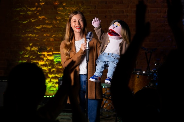 Photo portrait of female ventriloquist during show with puppet