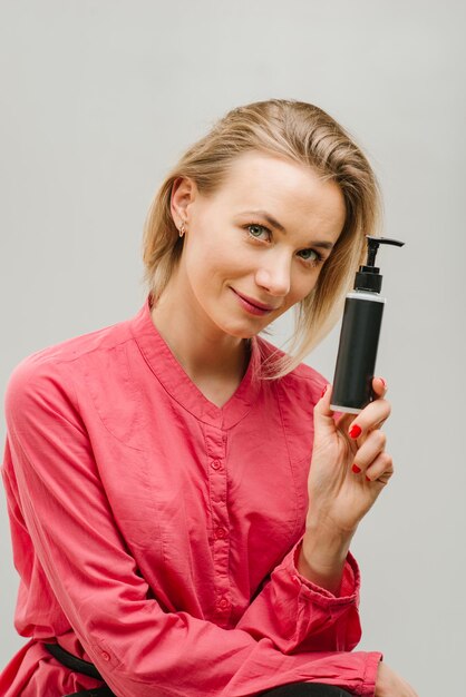 Portrait of female with cosmetics bottle in hand