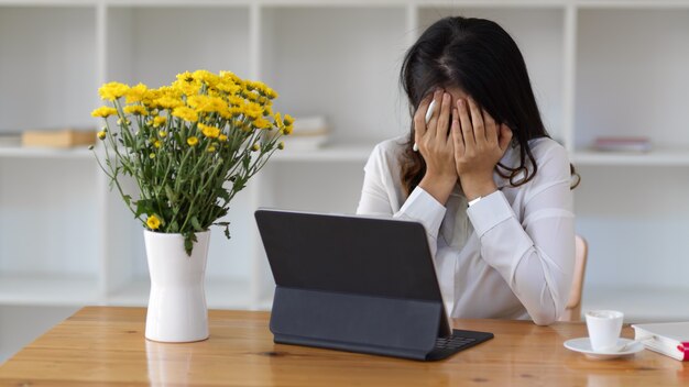 사무실 방에서 디지털 태블릿으로 작업하는 동안 화가 느낌 여성 노동자의 초상화