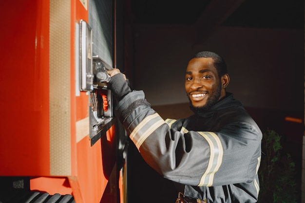 Portrait of a firefighter standing in front of a fire engine