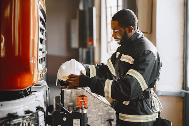 Ritratto di un vigile del fuoco in piedi davanti a un'autopompa antincendio