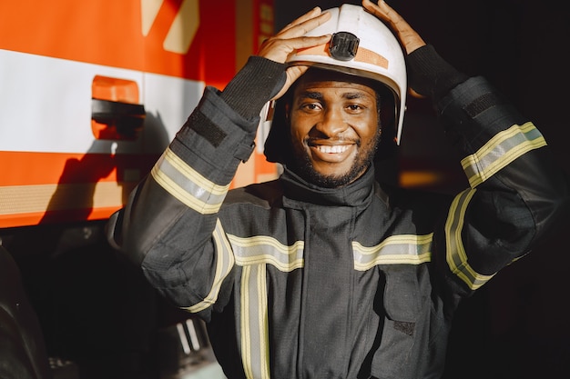 Portrait of a firefighter standing in front of a fire engine