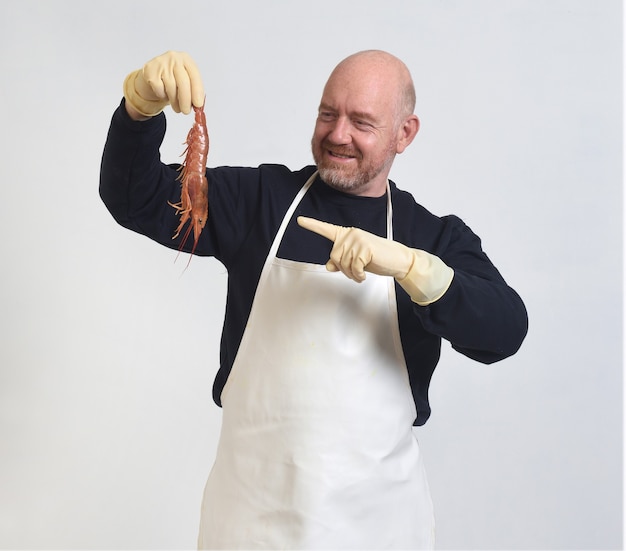 Portrait of a fishmonger showing and pointing with finger a prawns on white background