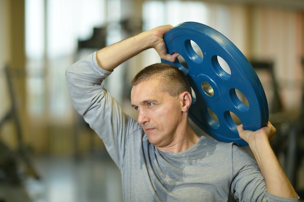 Photo portrait of fit man exercising at the gym