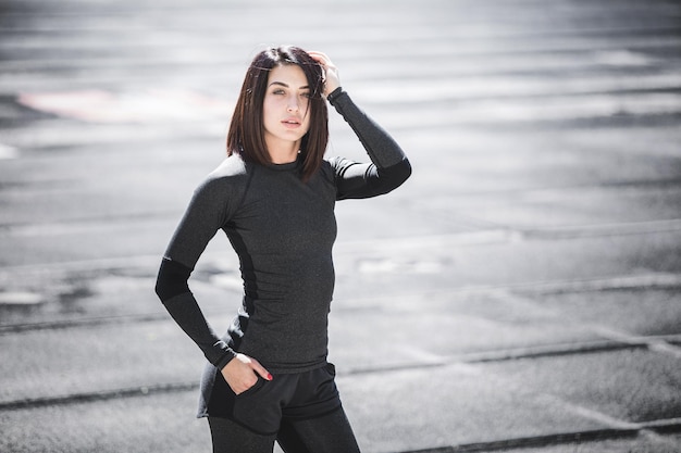 Portrait of fit and sporty young woman doing stretching in city