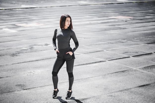 Portrait of fit and sporty young woman doing stretching in city