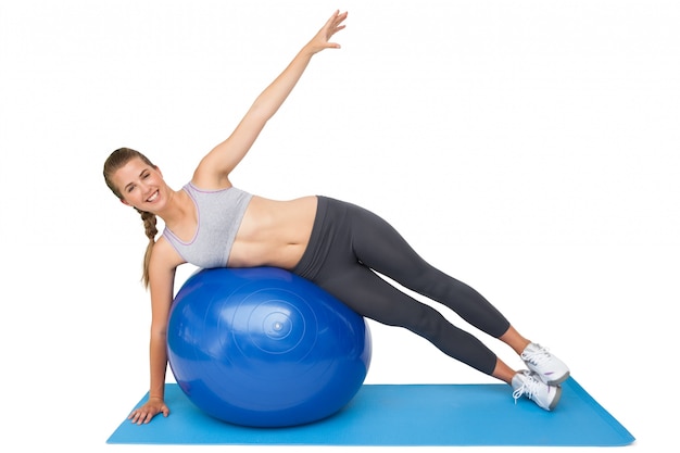 Portrait of a fit woman stretching on fitness ball