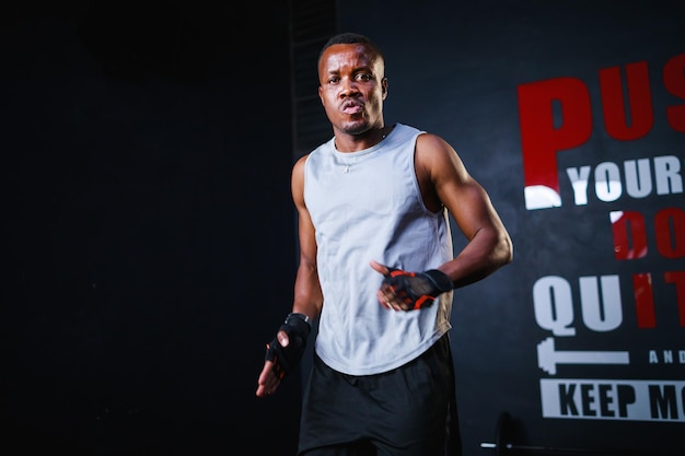 Portrait of fit young African American man posing in gym sports and health care concept