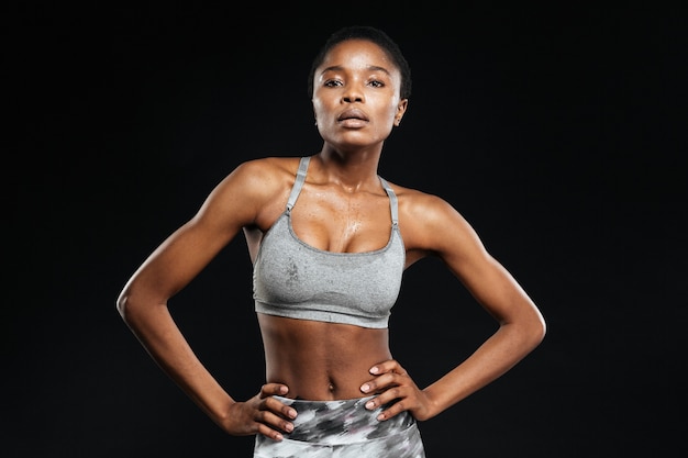 Portrait of a fitness woman posing isolated on a black wall