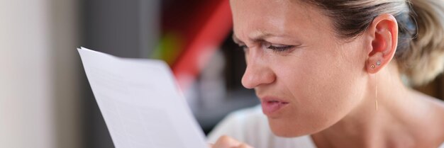 Portrait of focused female trying read text squinting to see more clearly female having