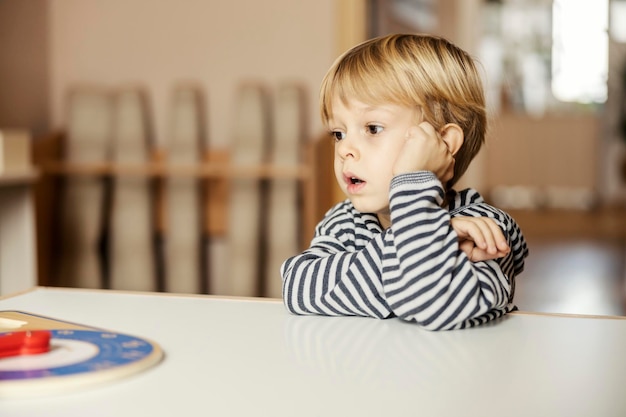 Portrait of focused little boy staring at something during his play break