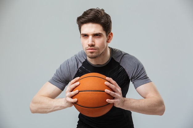 Ritratto di un giovane sportivo concentrato che gioca a basket