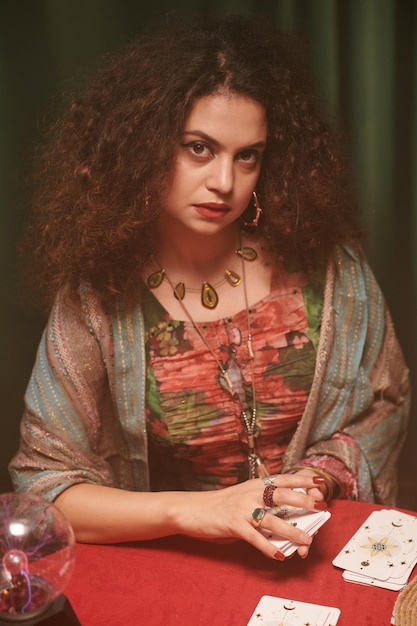 Portrait of fortune teller shuffling tarot cards and looking at camera