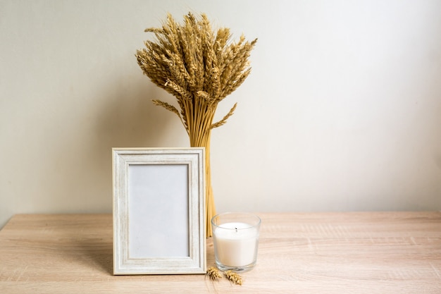 Portrait frame mock up with dried flowers on wooden table. High quality photo