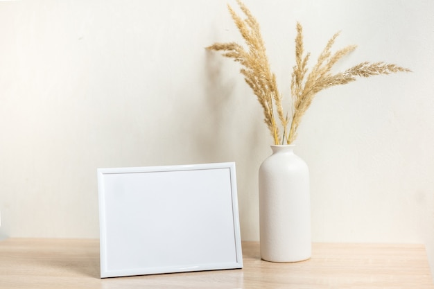 Portrait frame mock up with dried flowers on wooden table