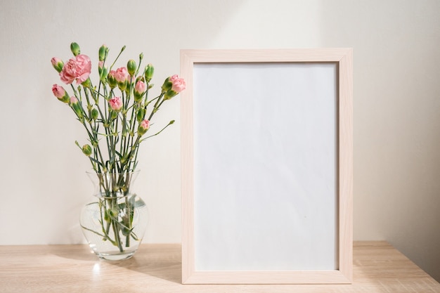 Portrait frame . Modern glass vase with rose carnation