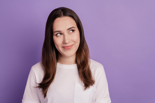 Portrait of friendly nice cute girl wondered look empty space minded isolated over violet color background