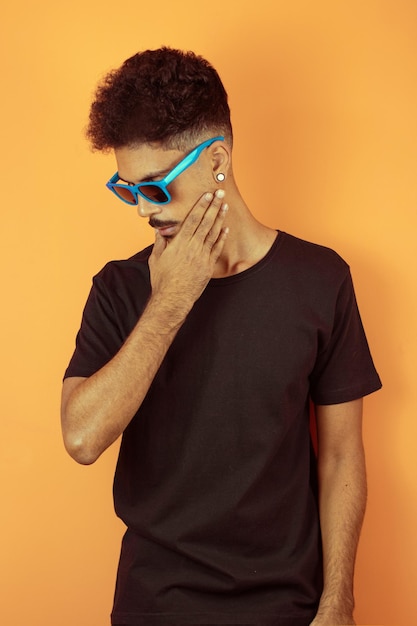 Portrait of a friendlylooking african american man with afro hairstyle smiling isolated on orange copy space