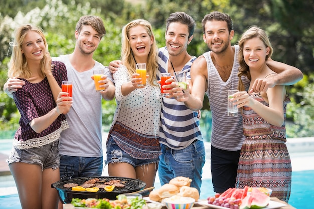 Portrait of friends having juice at outdoors barbecue party