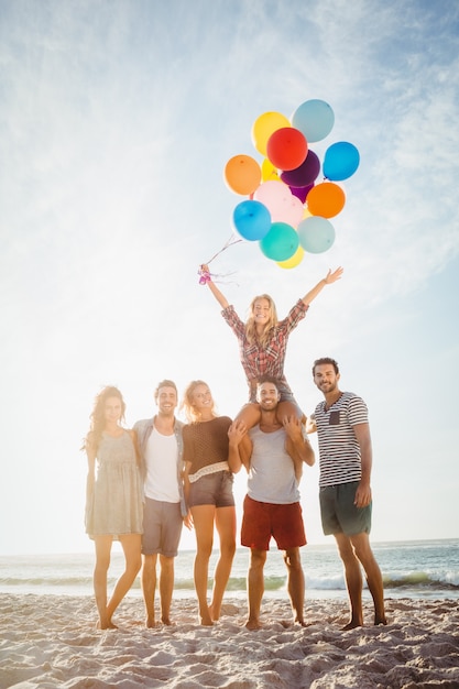 Portrait of friends holding balloon