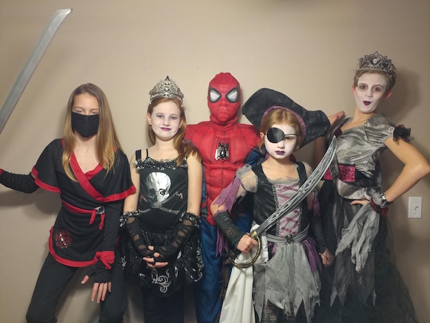 Photo portrait of friends posing in various costumes against wall