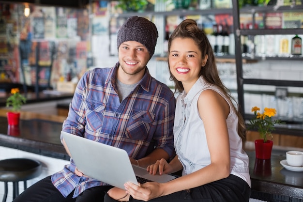 Portrait of friends using laptop in restaurant