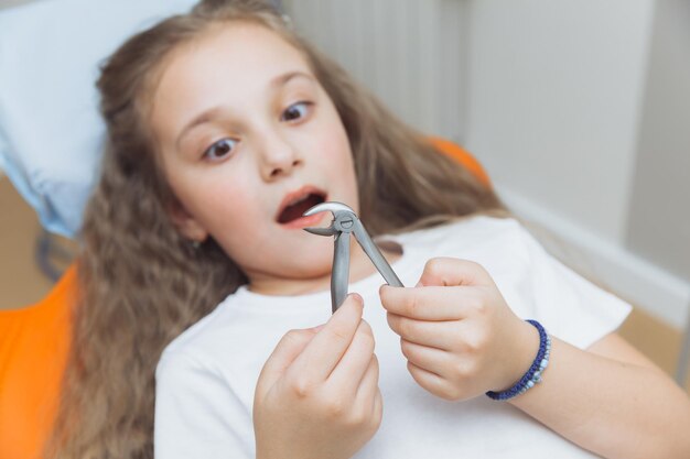 Portrait of a frightened little girl in the dentist's office dentist removed a little girl's tooth