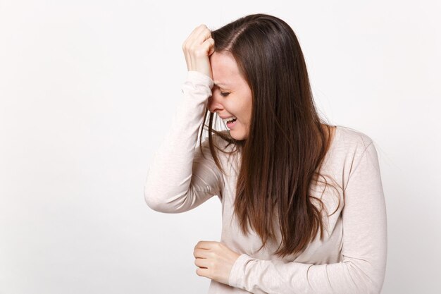 Ritratto di giovane donna stanca piangente frustrata in abiti leggeri che mette la mano sulla testa abbassata isolata su sfondo bianco in studio. persone sincere emozioni, concetto di stile di vita. mock up spazio di copia.