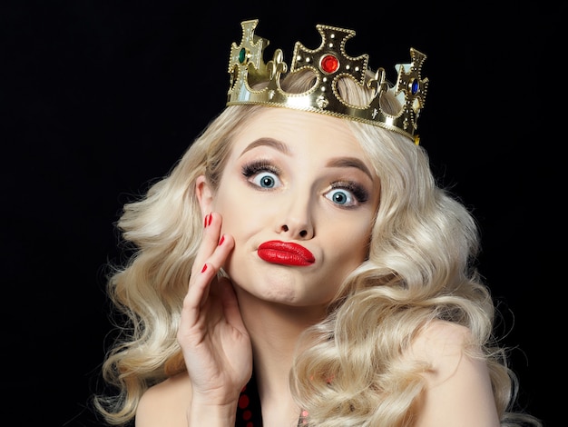 Portrait of funny beautiful young blondie princess makes faces