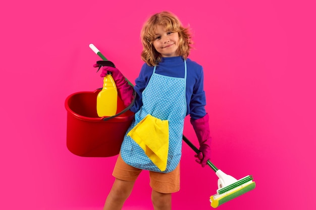 Portrait of funny child cleaning housekeeping and home cleaning\
concept child use duster and gloves for cleaning studio isolated\
pink background