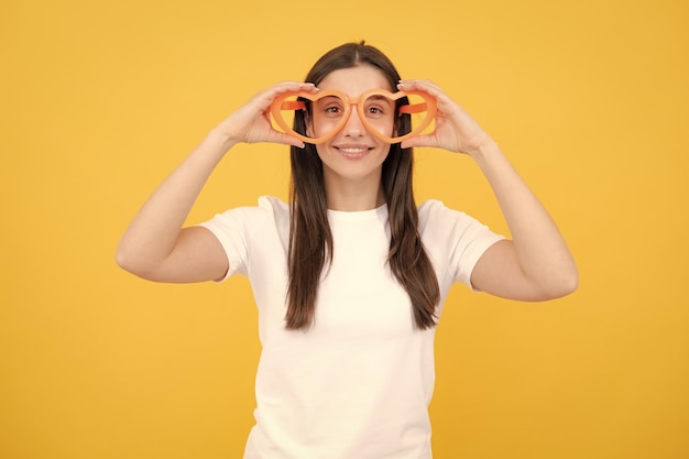 Portrait funny girl wearing cool party glasses Cheerful young girl smiling with heartshape glasses