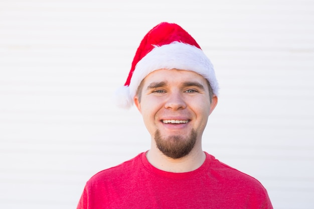 Portrait of funny handsome man in santa hat have fun on white