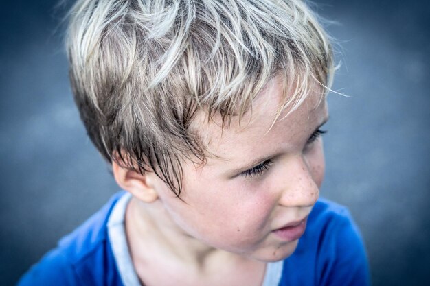 Portrait of a funny happy mischievous cheerful cute blond blue eyed boy making freckles dirty face while playing laughing Nursery happy childhood education family relationship concept