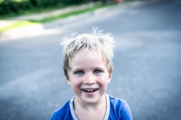 Portrait of a funny happy mischievous cheerful cute blond blue eyed boy making freckles dirty face while playing laughing Nursery happy childhood education family relationship concept