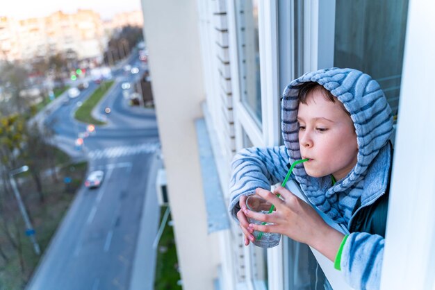 Портрет забавного милого маленького мальчика, пускающего мыльные пузыри с балкона Малыш играет дома