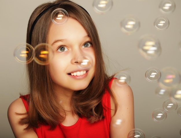 Portrait of funny lovely little girl witj soap bubbles