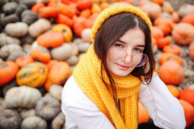 Photo portrait of a funny young girl in the autumn weather in warm clothes and hat