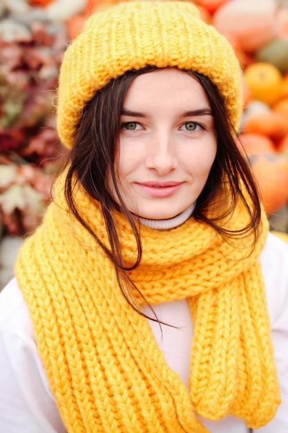 Portrait of a funny young girl in the autumn weather in warm clothes and hat