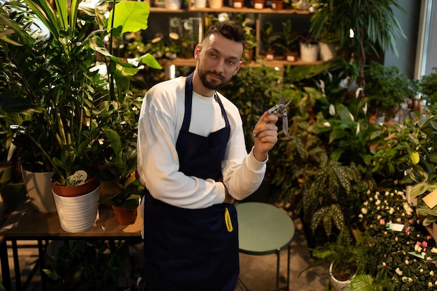 Ritratto di un fiorista giardiniere sullo sfondo di un negozio di fiori