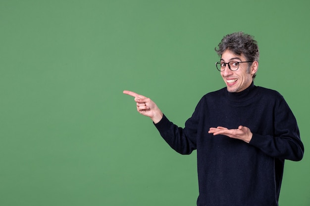 Portrait of genius man dressed casually in studio shot green surface horizontal male color