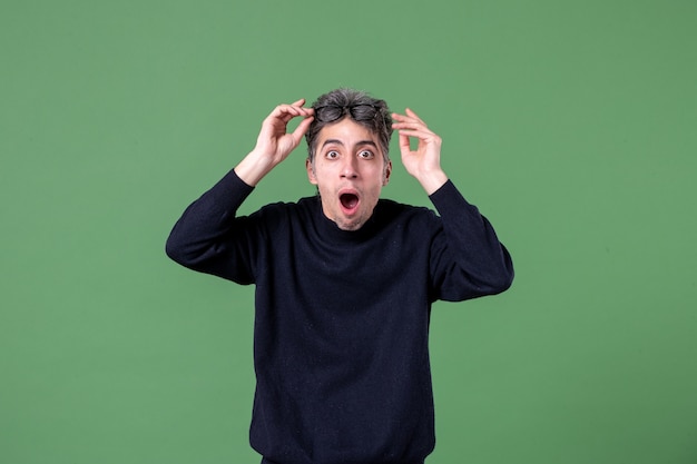 Portrait of genius man dressed casually in studio shot shocked green wall