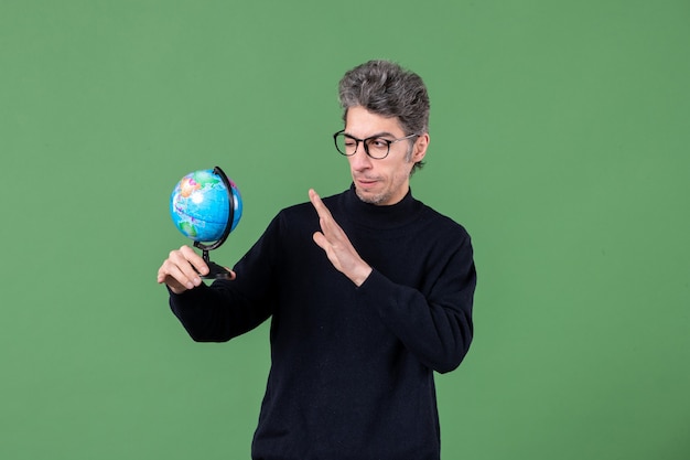 地球グローブスタジオショット緑の背景空気教師自然惑星海を保持している天才男の肖像