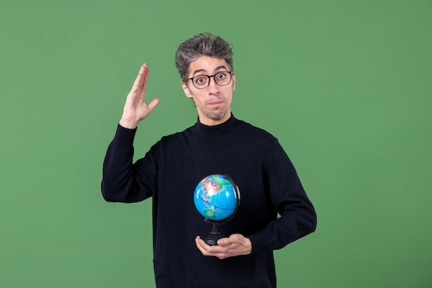 Photo portrait of genius man holding earth globe studio shot green background nature planet air sea space